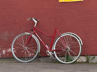 Rotes Centurion Damenfahrrad an roter Wand gelehnt Puzzle, Vorschau