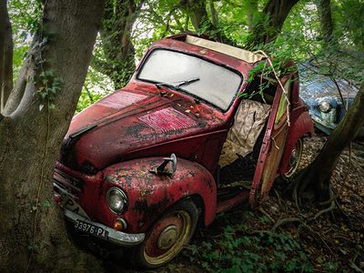 Legpuzzel Een roestige, verlaten klassieke auto die overwoekerd is door bomen