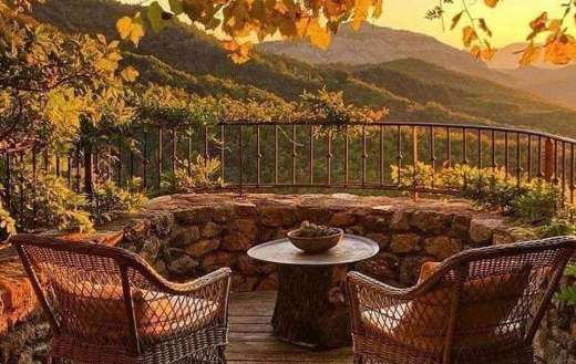 A very cozy rustic terrace with golden yellow orange tree leaves