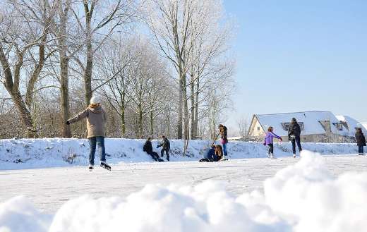 People ice skating in like frozen lake