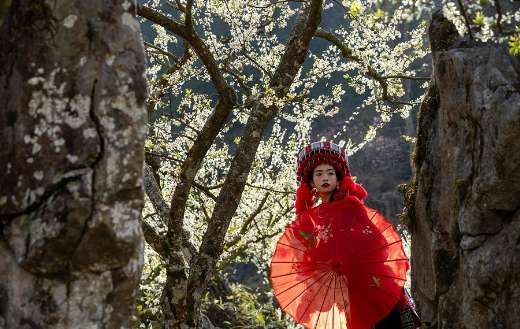 Woman with traditional clothing with red parasol
