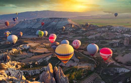 Breathtaking sunrise with numerous hot air balloons
