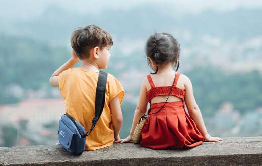 Two young children looking in the horizon
