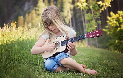 Young girl playing small guitar