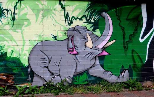 Mural shows a gray elephant in green jungle like setting
