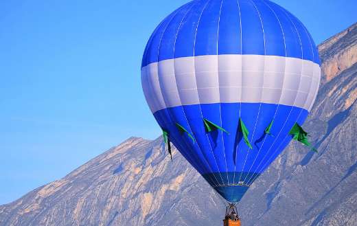Blue and white hot air balloon with green flags