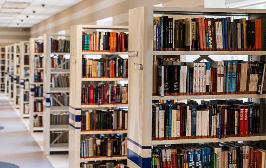 Modern library with rows of tall white bookshelves