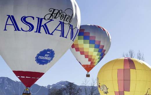 Colorful air balloon flight over snowy Bavarian Alps