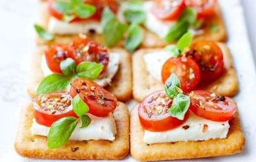 Mini crackers with mozzarella cherry tomatoes basil