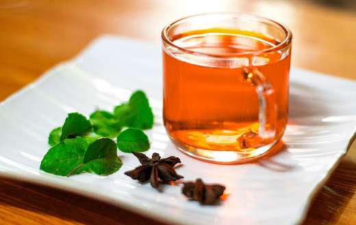 Transparent tea glass with orange brownish tea